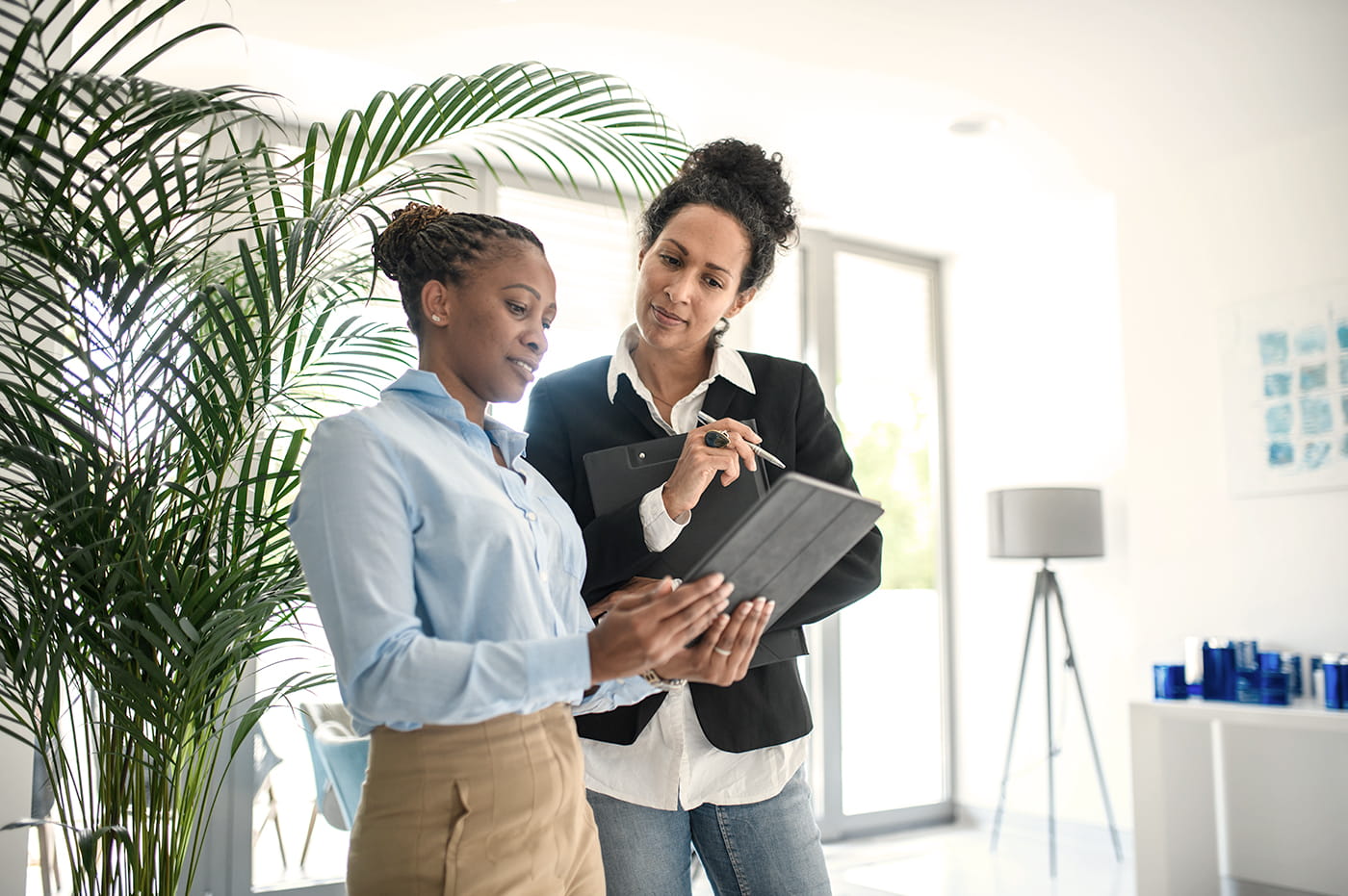 Two businesswomen looking at a tablet.  