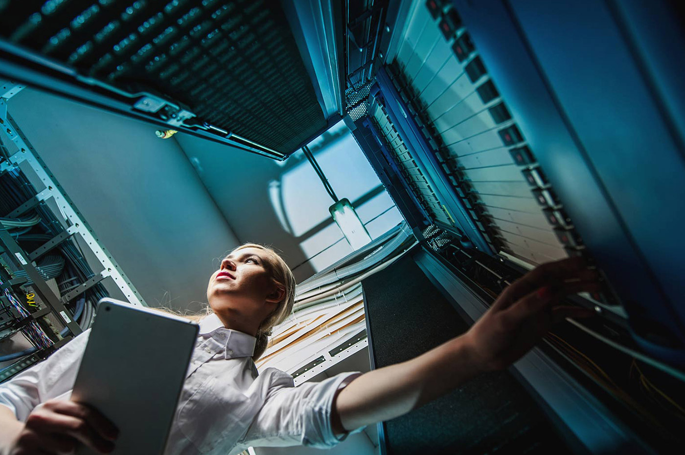 A woman working on several computer servers.