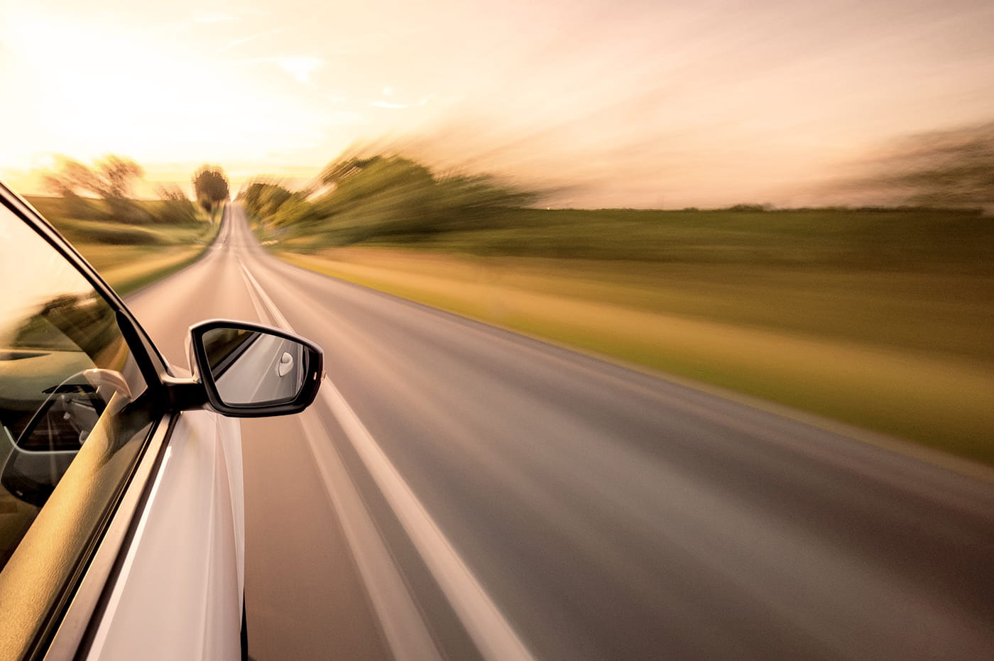 Car driving fast along a blurred highway.