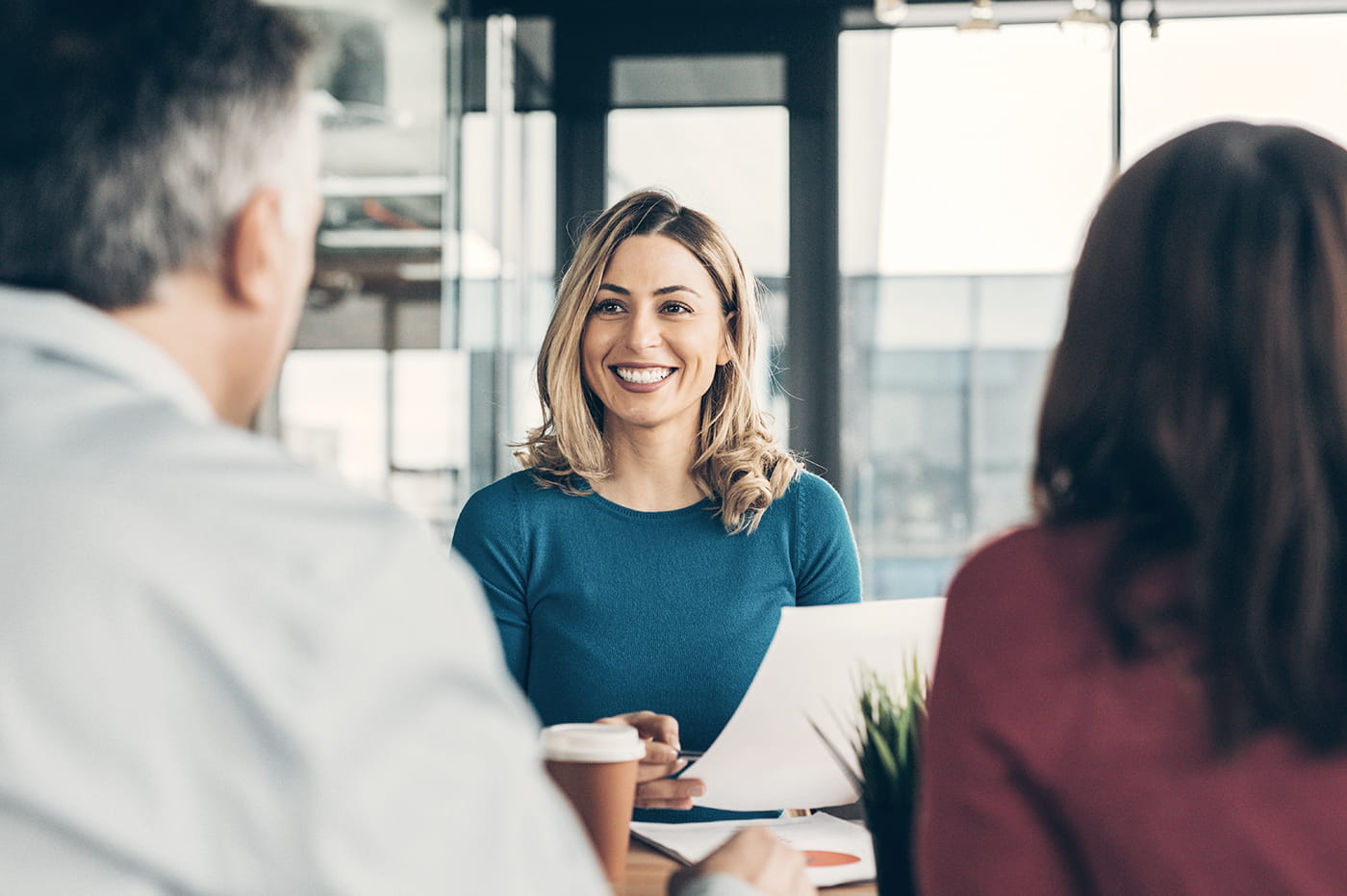 A business woman smiling at two people.