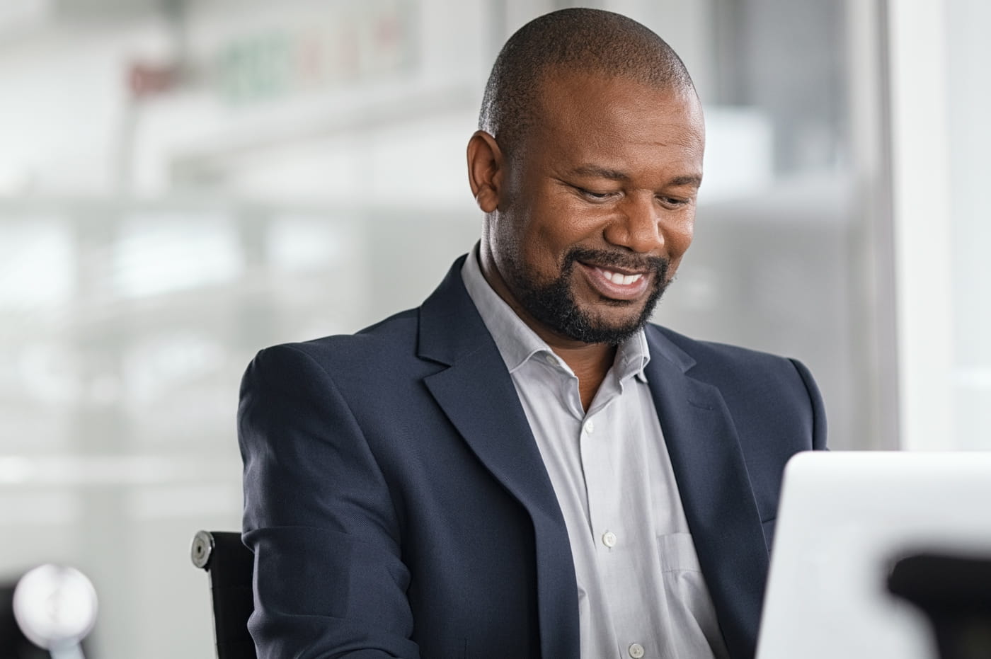 A man in a suit working on a computer.