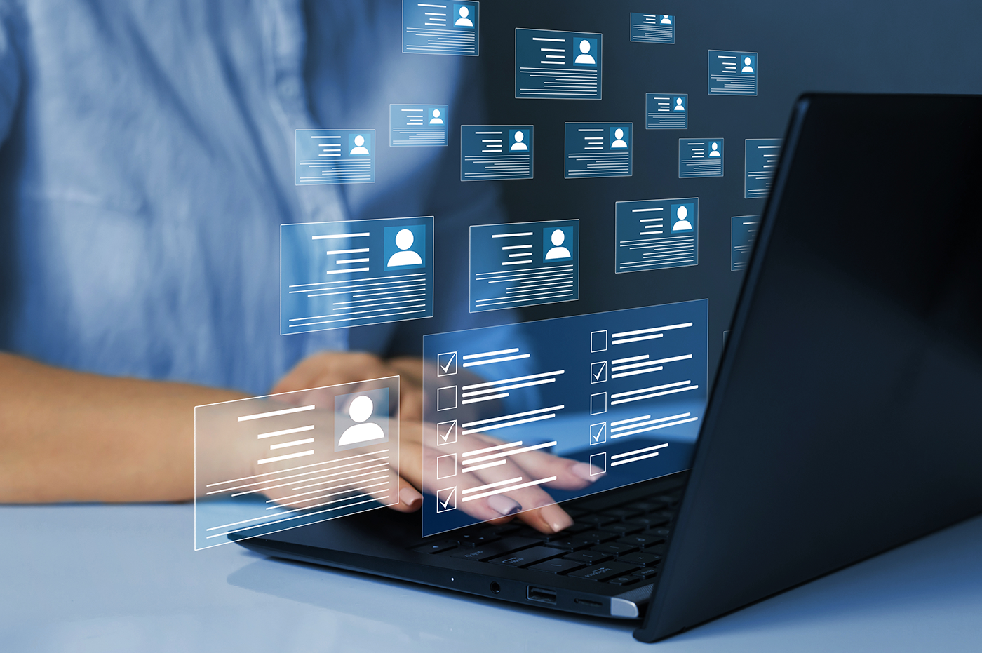 A person sitting in front of a computer with many digital checklists floating above the computer screen. 