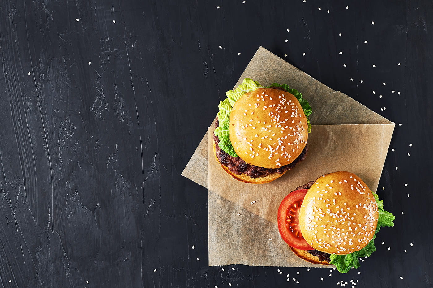 Two hamburgers on a paper wrapper.