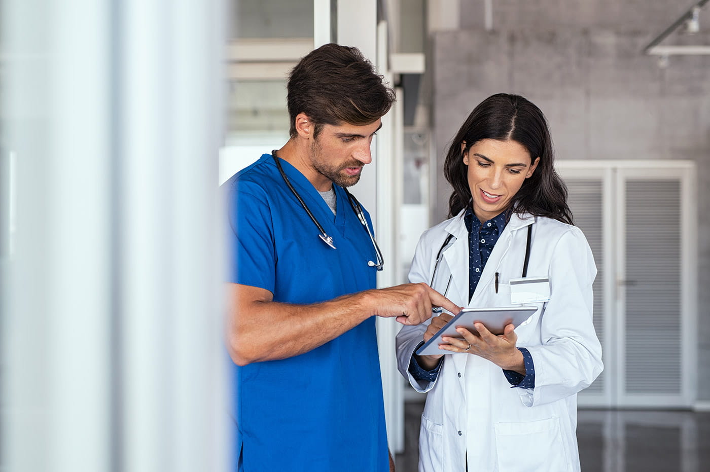 Two healthcare workers looking at information on a tablet.