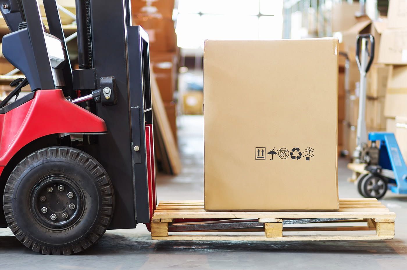 A small palletjack lifting a box.