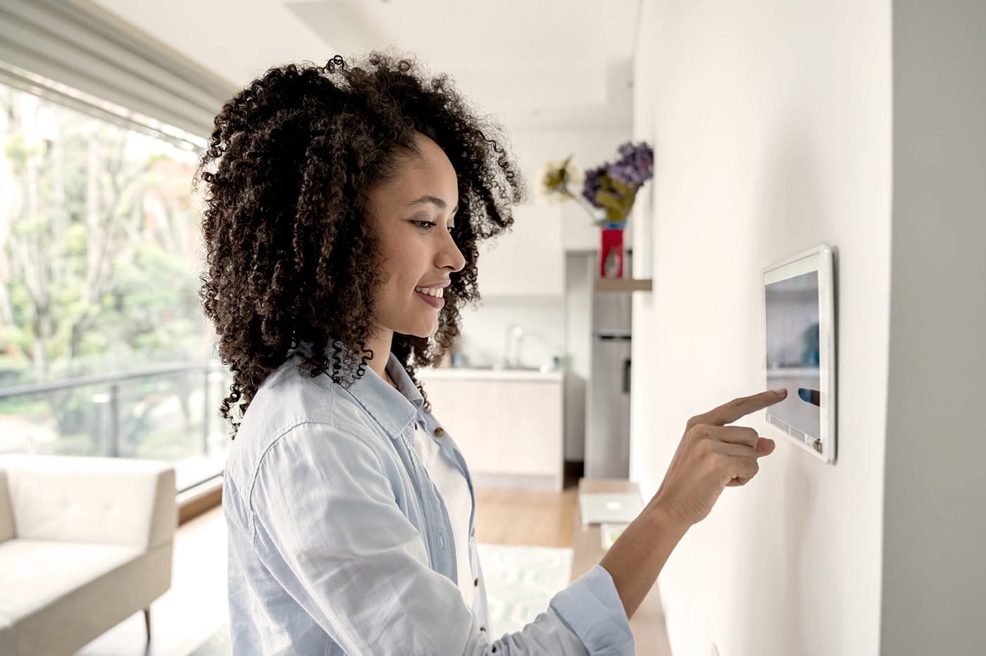 Woman standing next to a Digital Energy Thermostat 