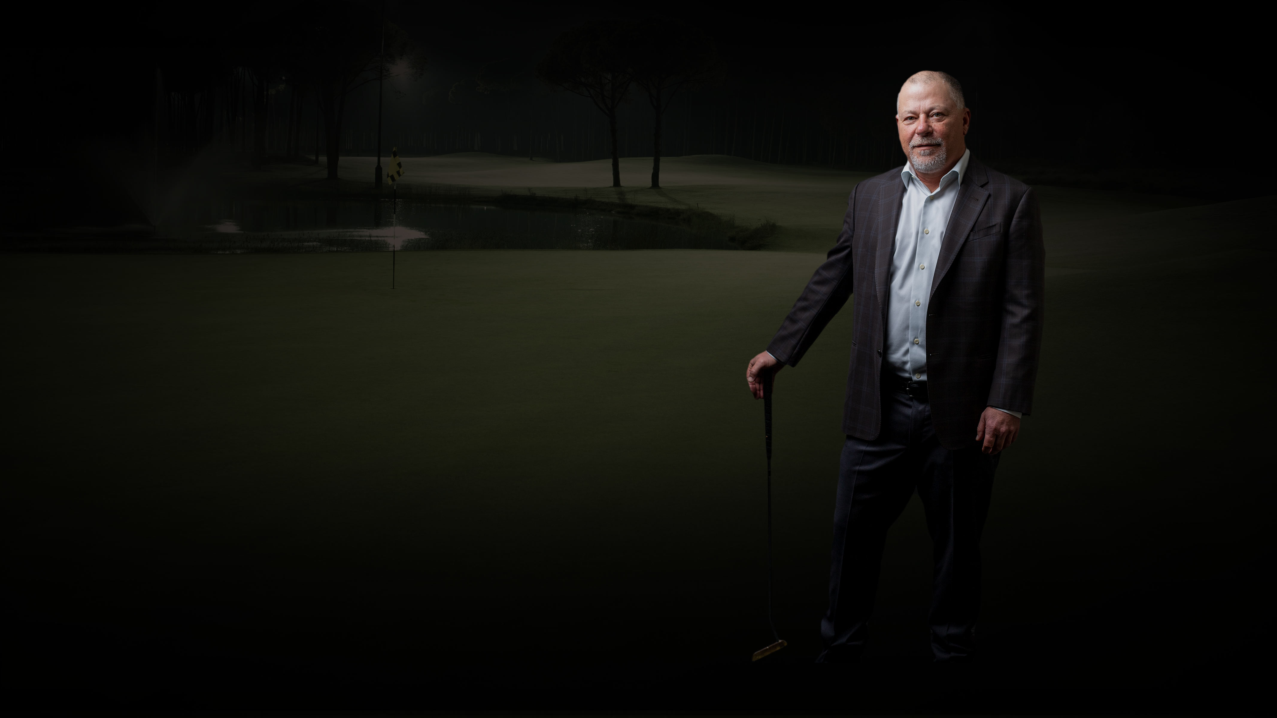 John Jenkins, VP, holding a golf club