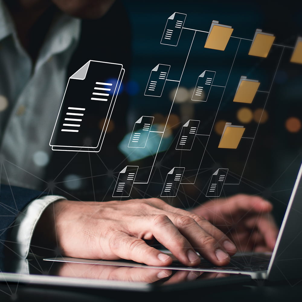A man typing on a laptop and folder and file icons.