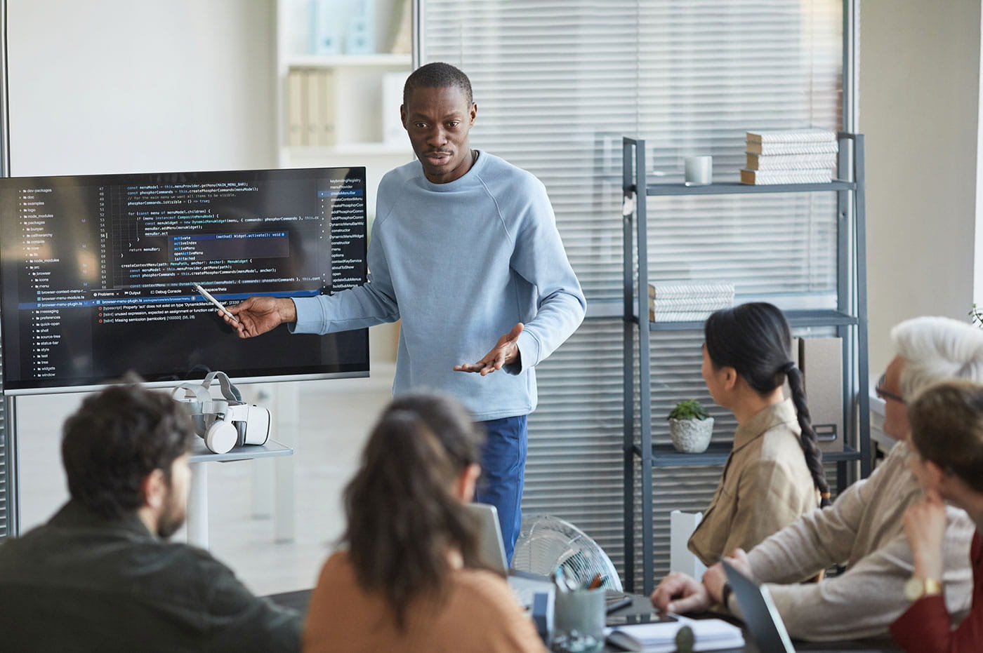 A man presenting something to a group of colleagues.