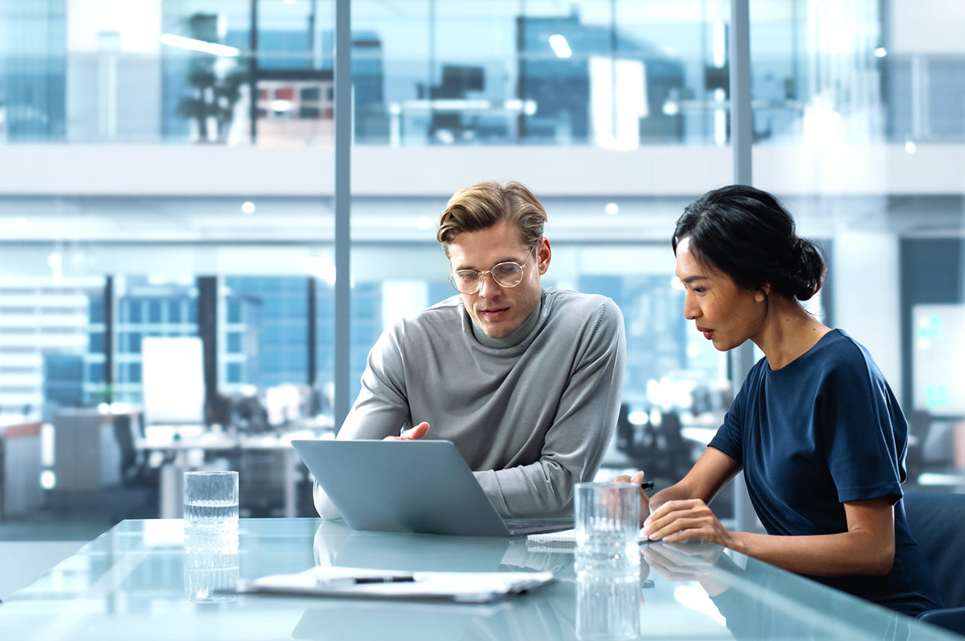 Two colleagues working together in a modern office.