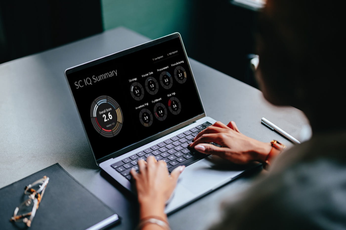 A person typing on laptop with SC IQ summary data on screen