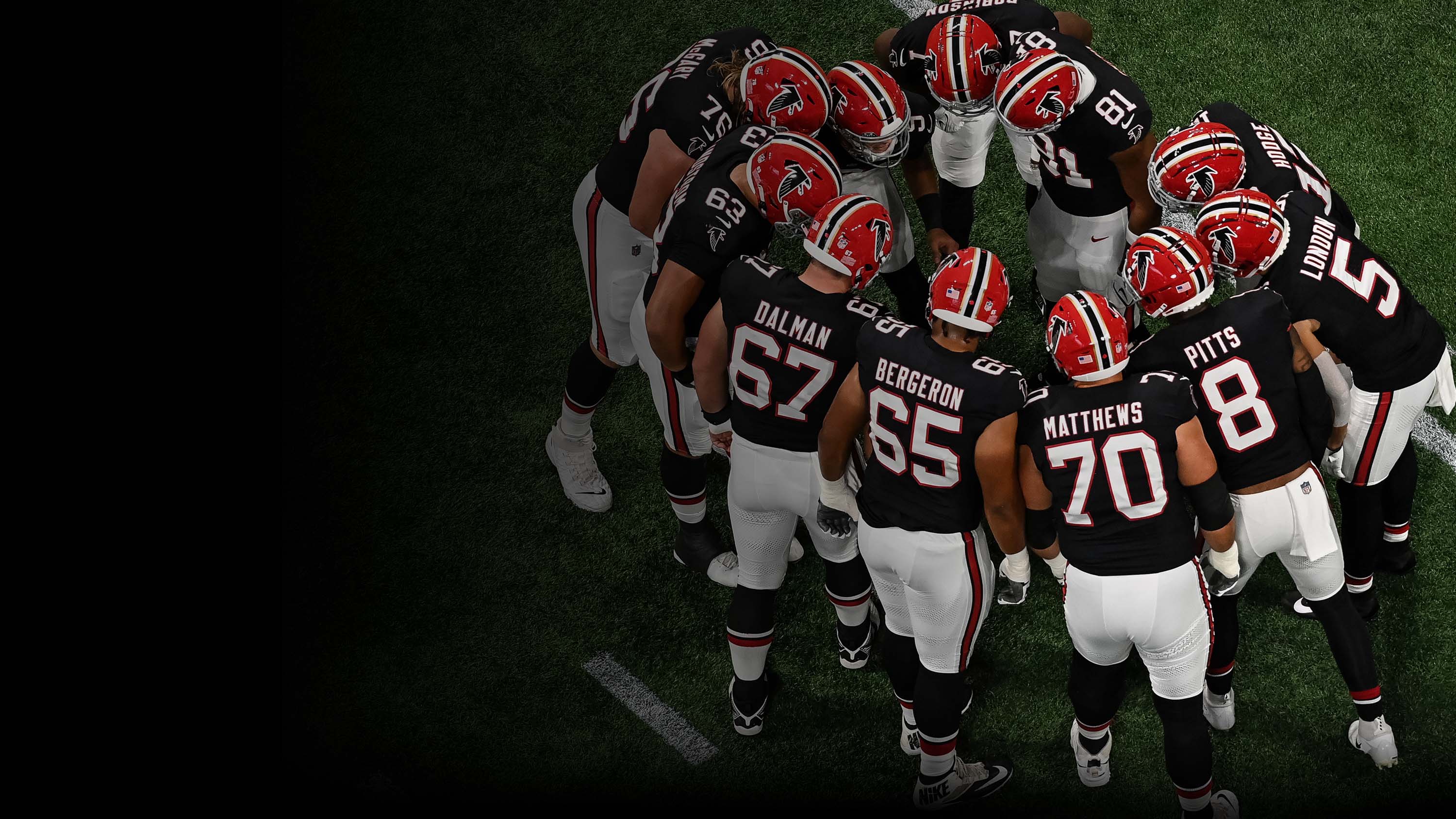 Atlanta Falcons football players in a team huddle.