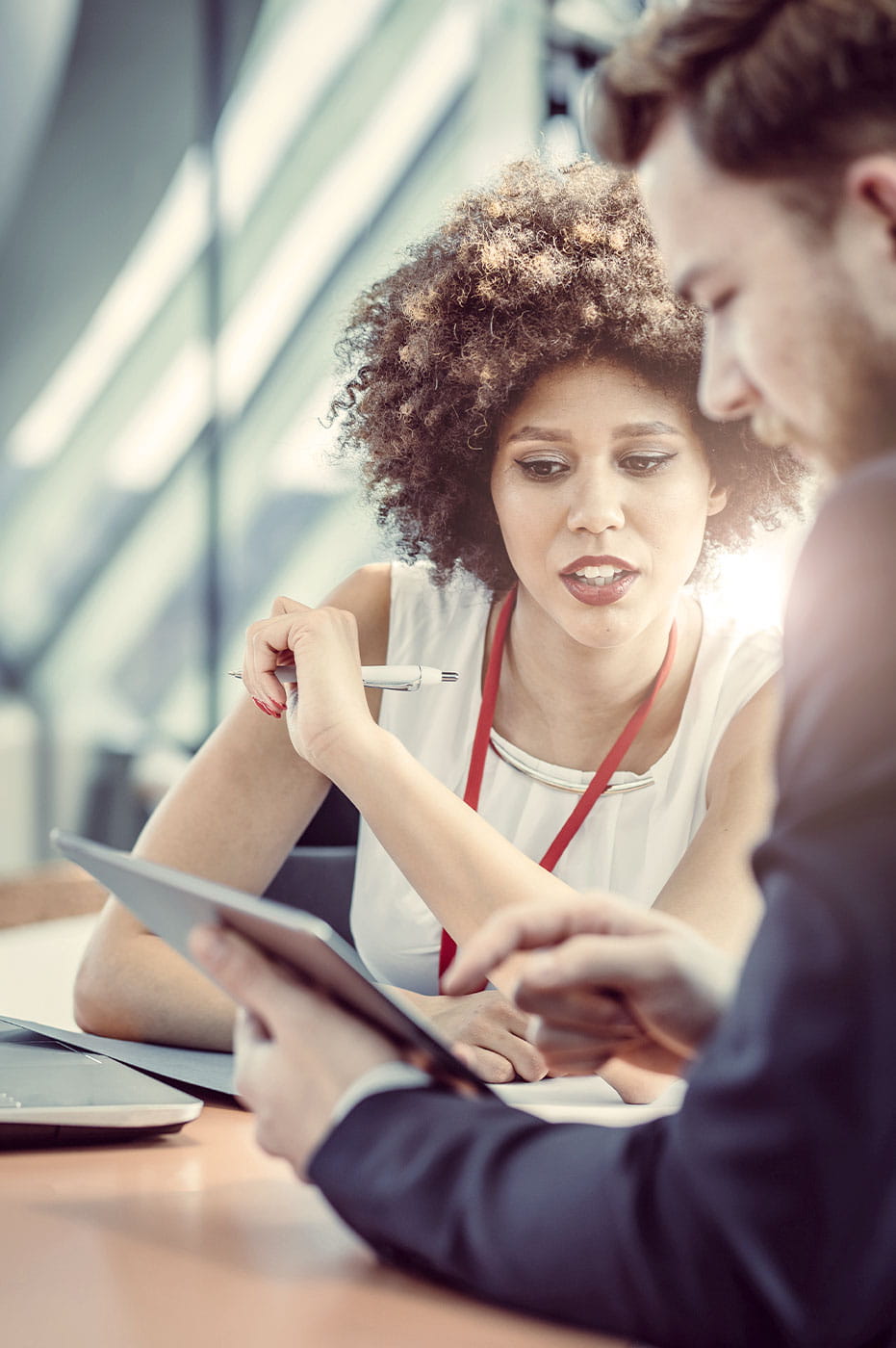 A man and woman working on a tablet.
