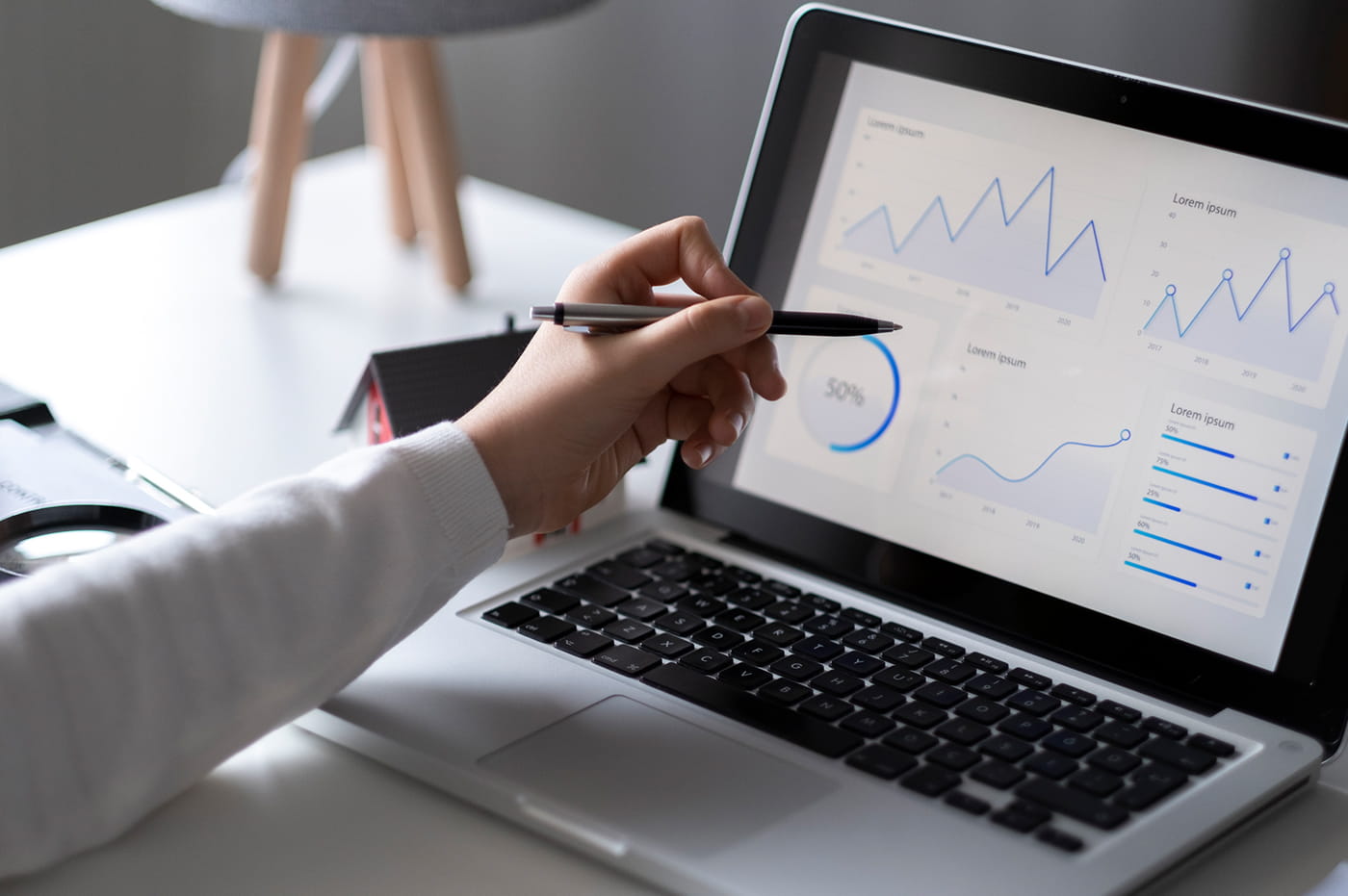 A person with a pen writing on a laptop