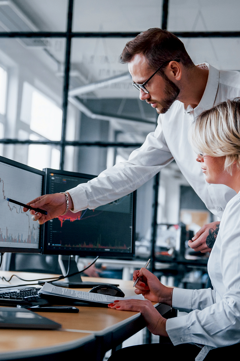 Two people working together on a desktop computer.