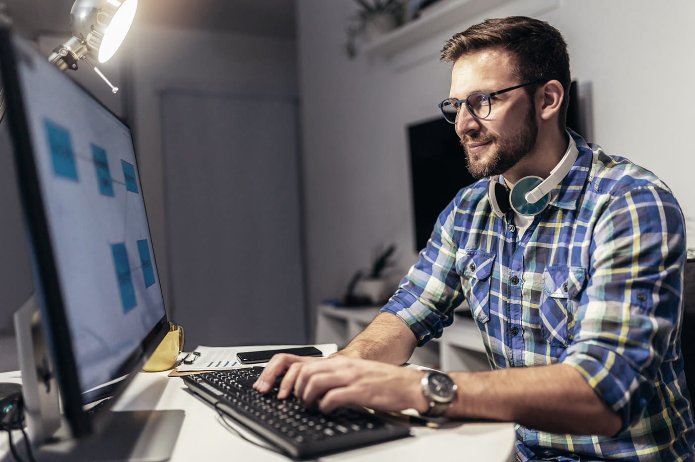 A developer working on a website page on a desktop computer.