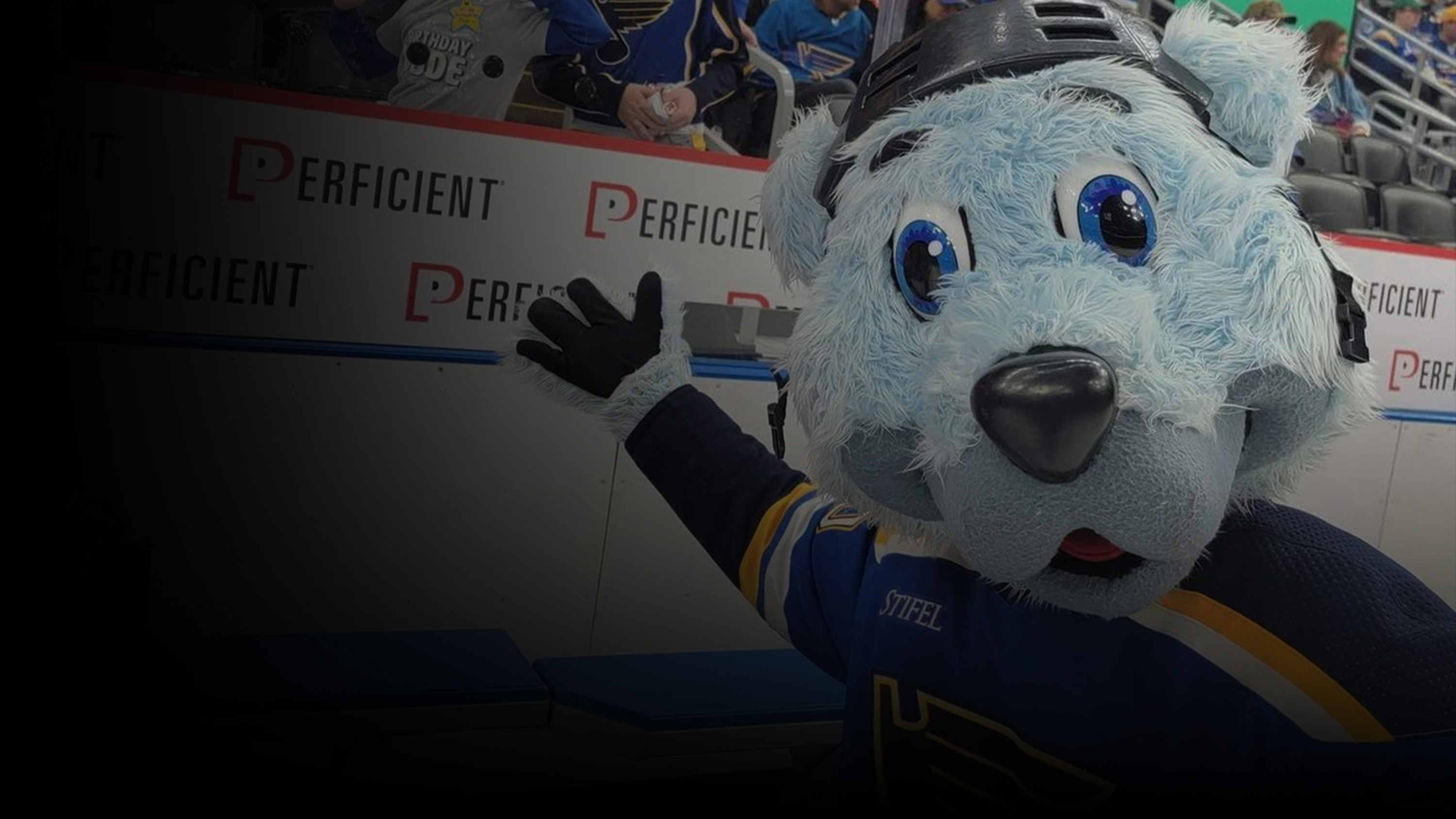 St. Louis Blues Hocket Mascot, Louie, in front of the Perficient sign.