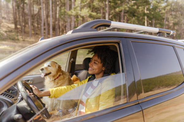 Woman driving a car with a dog