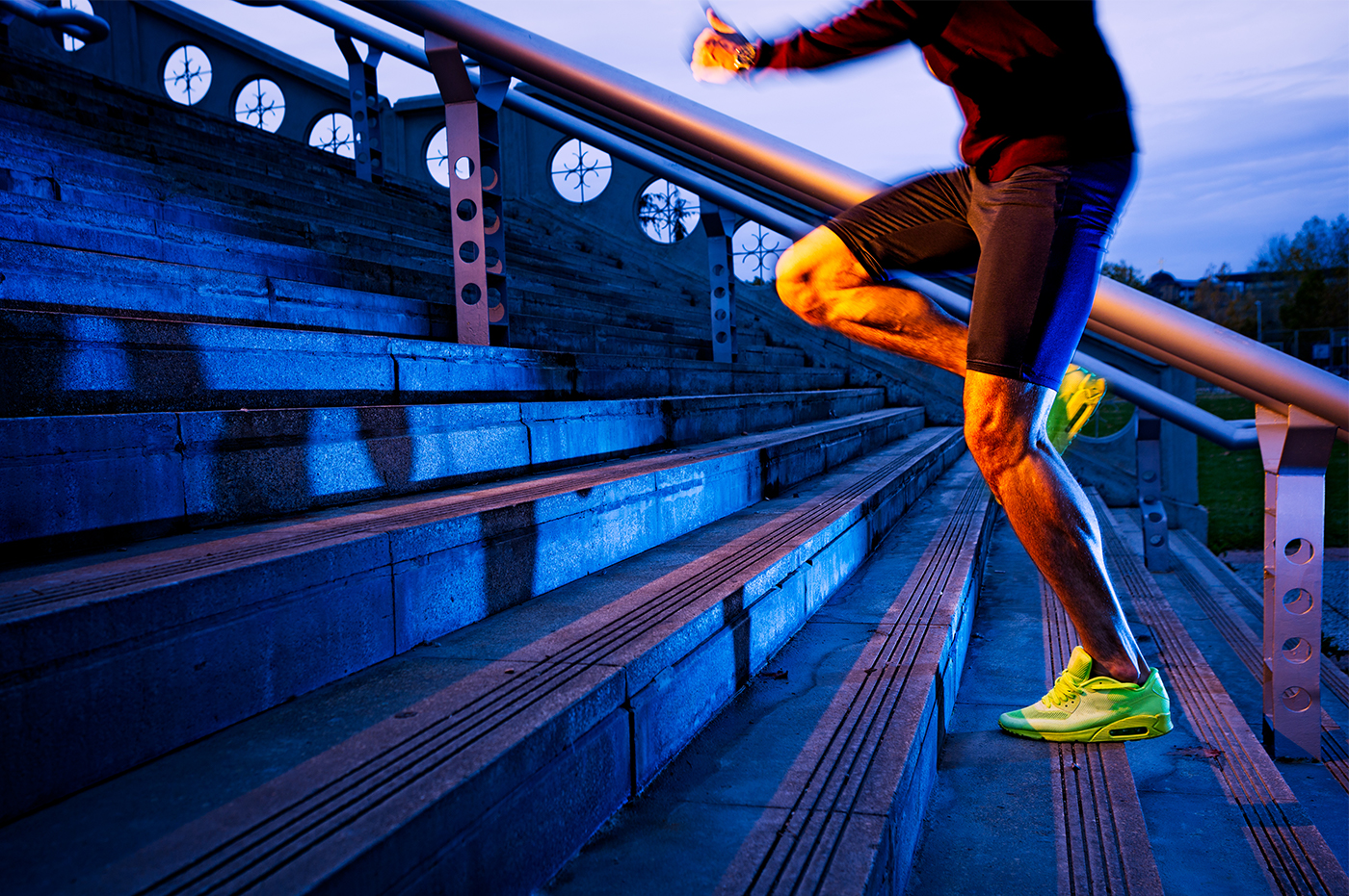 Man in athletic clothes and shoes running up outdoor stairs.