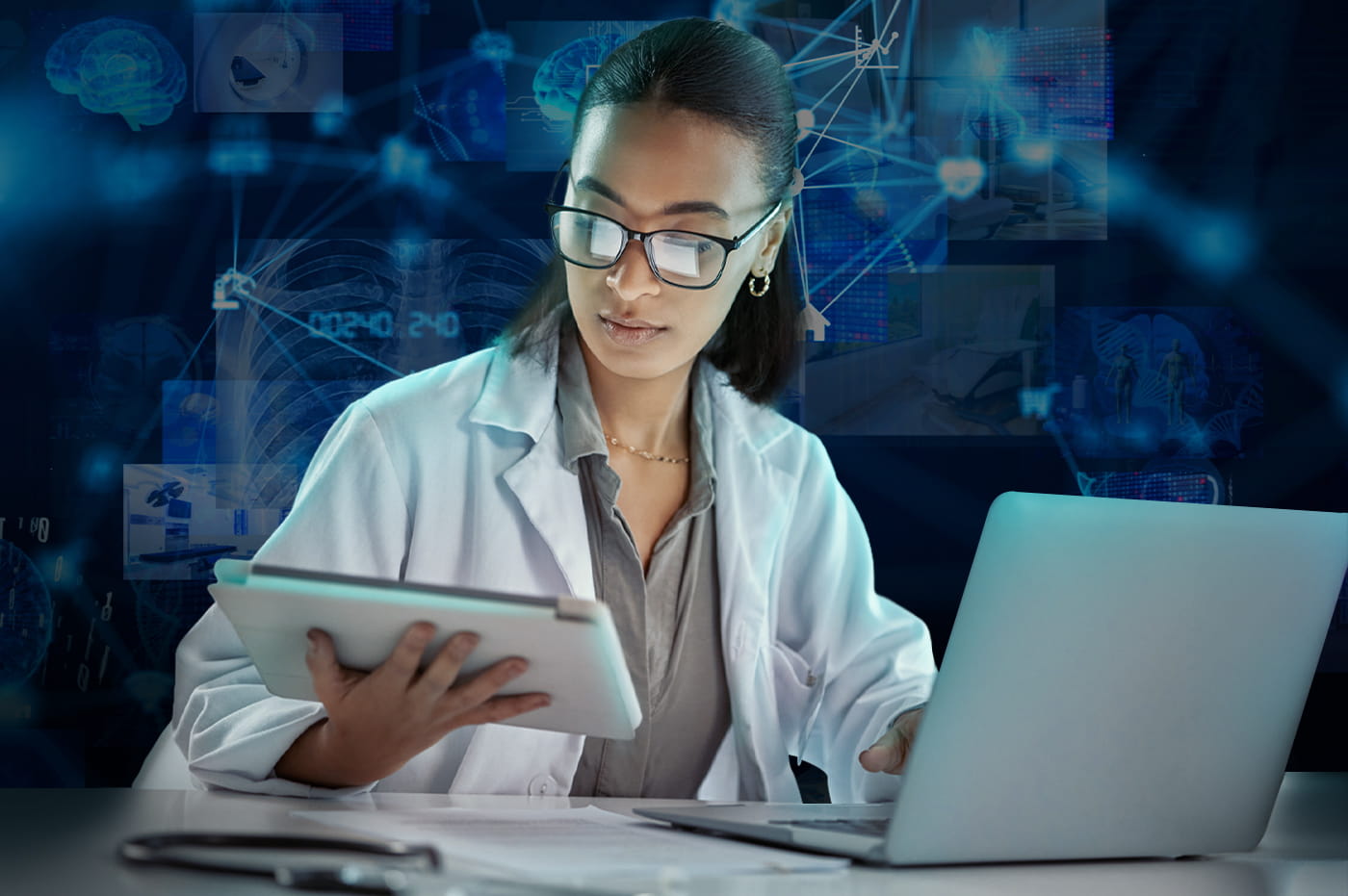 A female doctor using a computer and tablet.