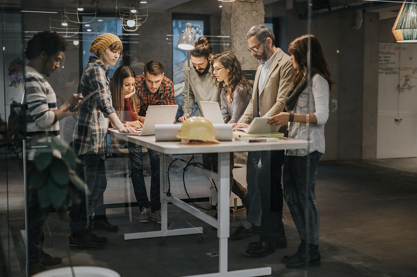 A group of young professionals gathered around a table having a meeting.