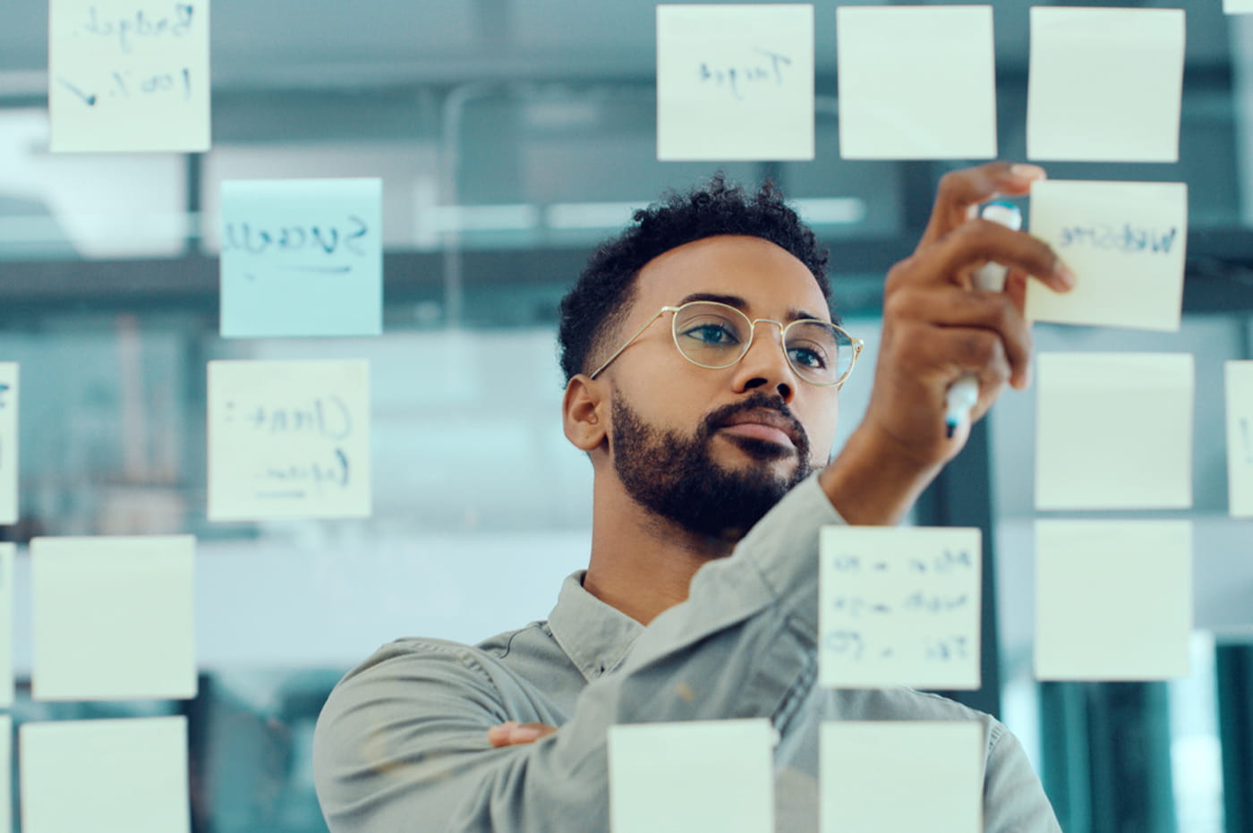 Man looking at a board full of sticky notes