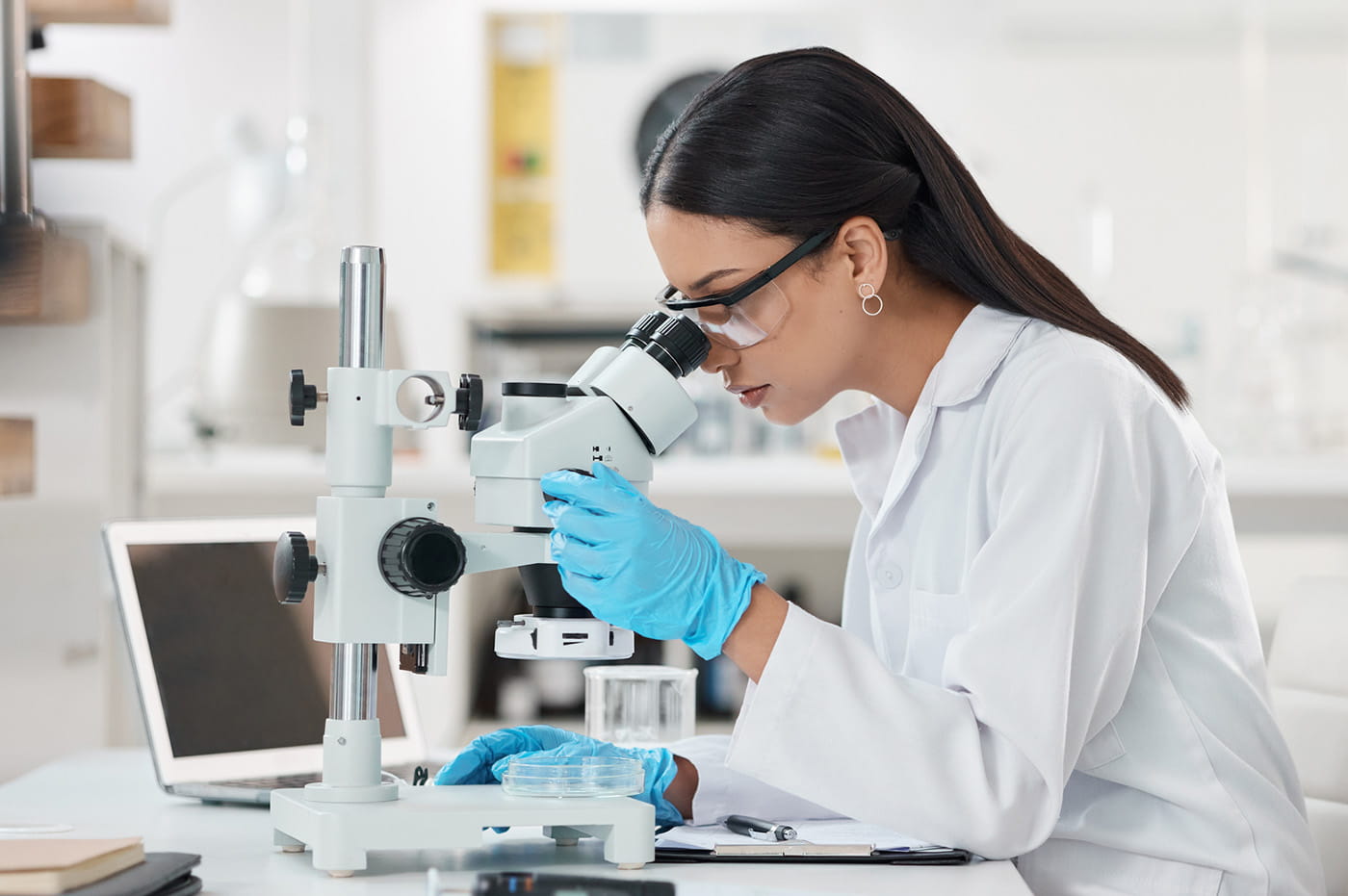 A medical professional looking through a microscope.