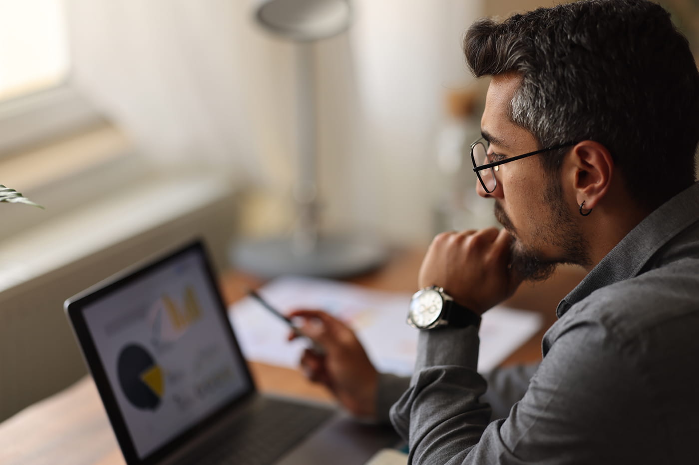 Man looking at a laptop screen with charts on it