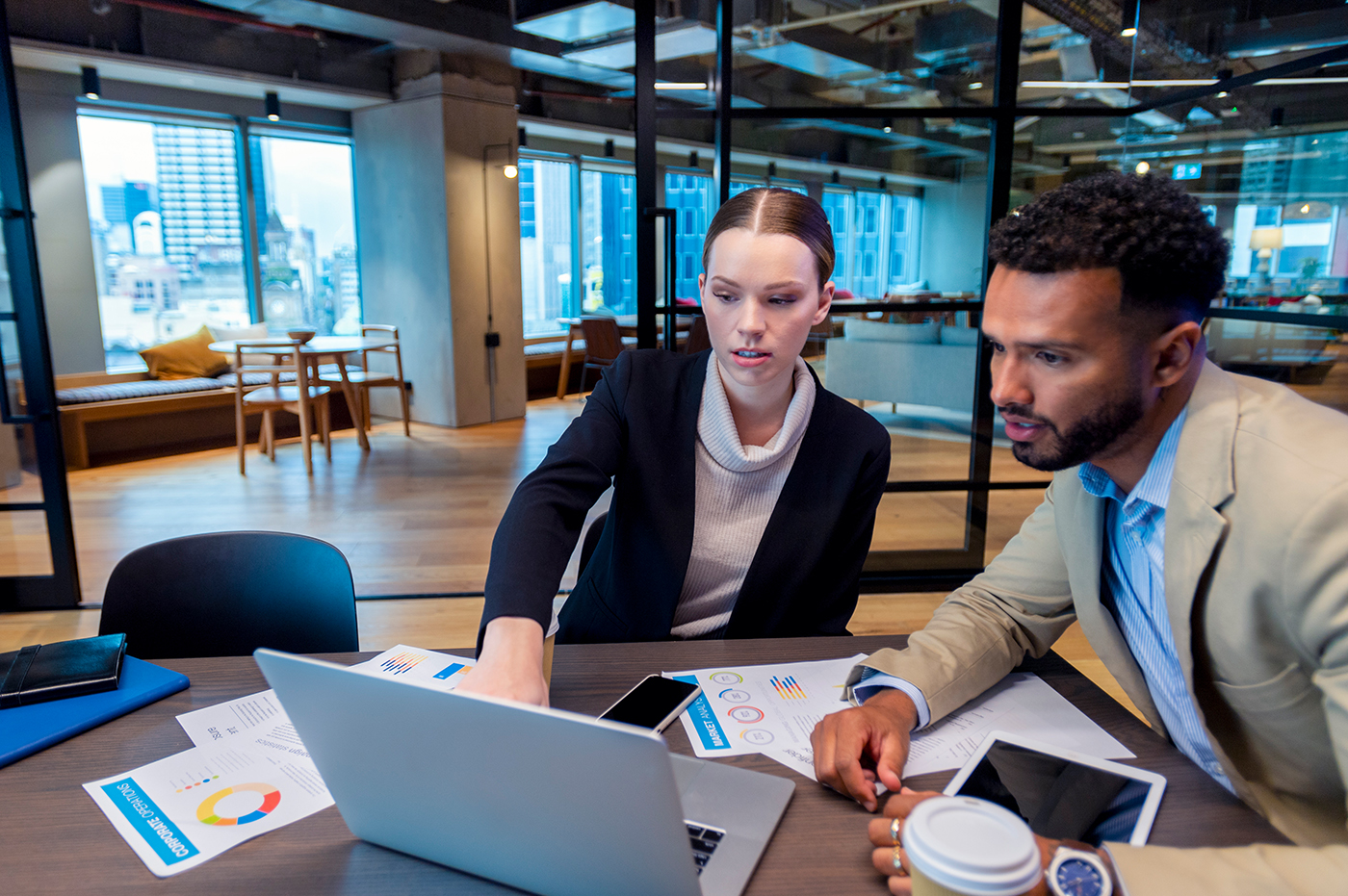 Two people looking at a laptop and working with data.